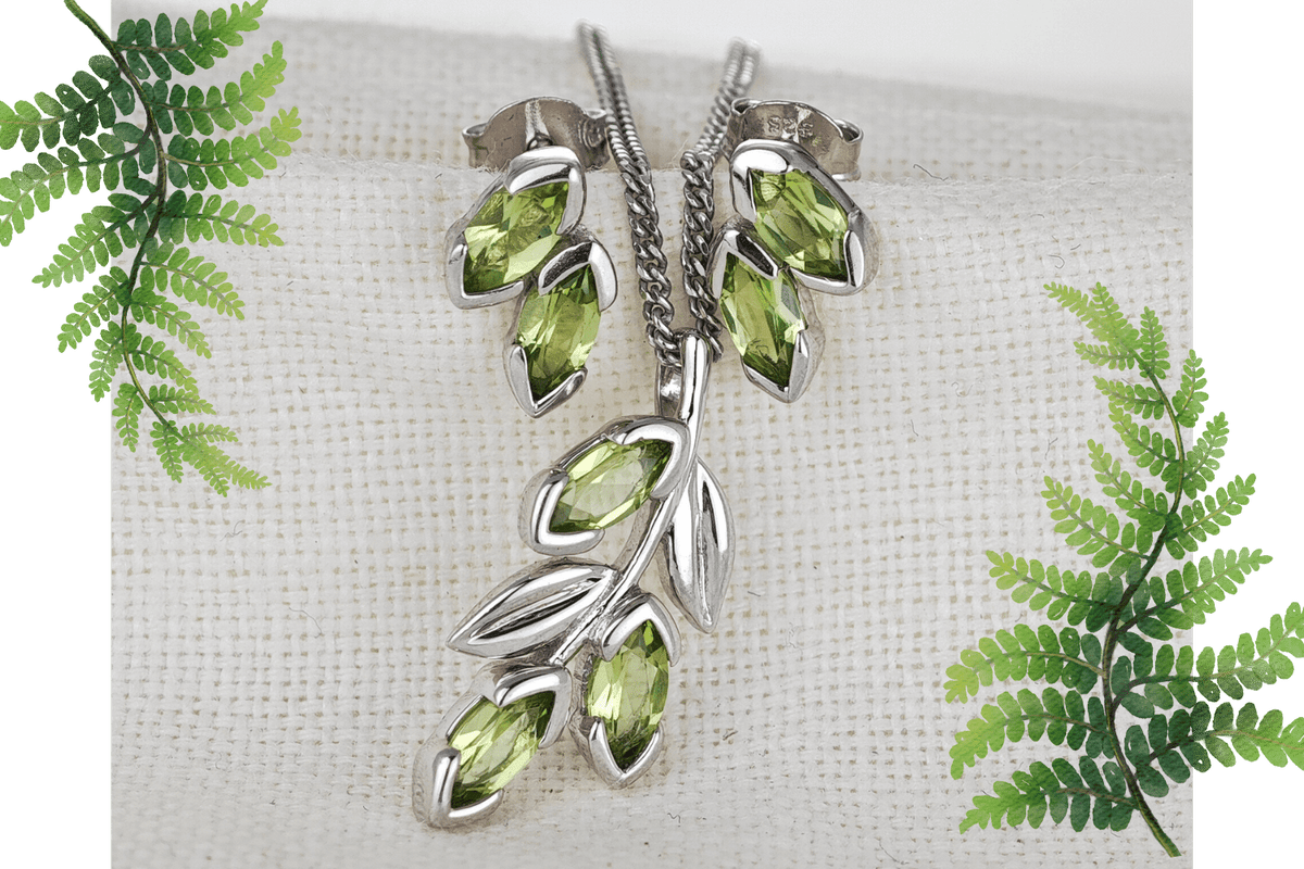 Peridot silver olive branch Jewellery on linen backfrop flagged by fern leaves