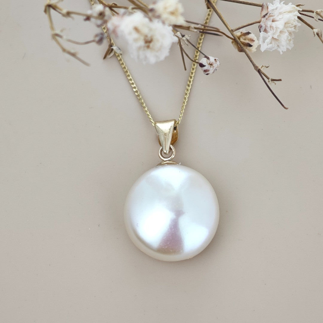 9ct gold disc pearl necklace on natural background