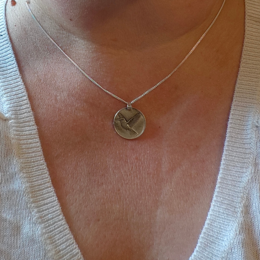 Hummingbird deep engraved sterling silver pendant on curb chain shown on neck
