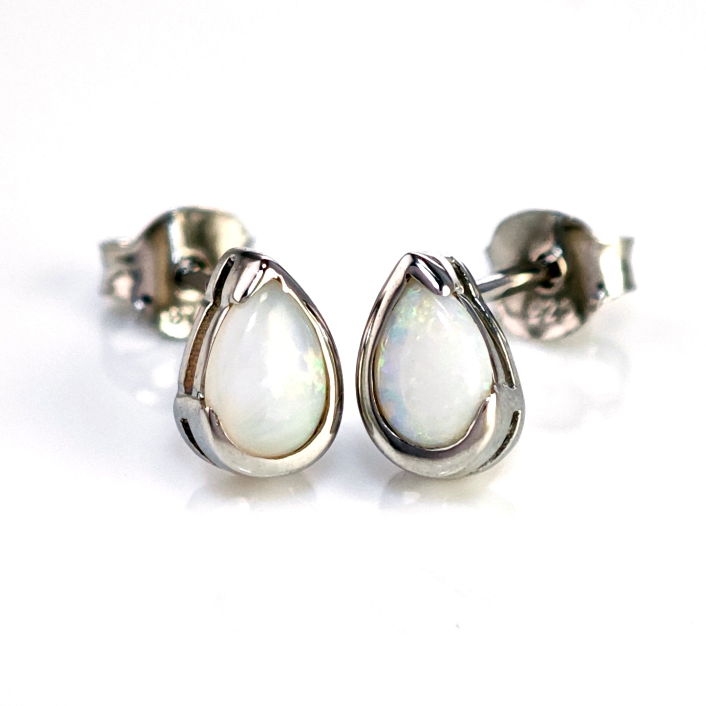 Teardrop-shaped opal earrings on a white background