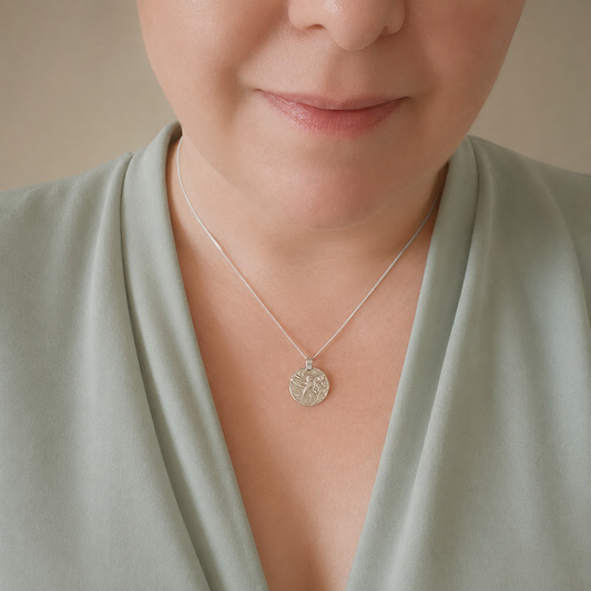 Model wearing the Hummingbird engraved sterling silver coin pendant necklace, handcrafted in the UK from recycled sterling silver