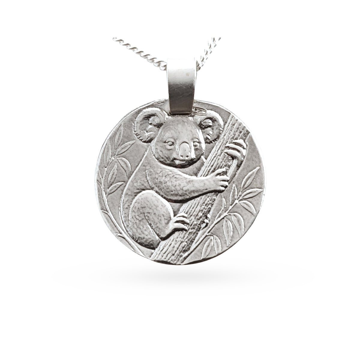 A round silver pendant necklace featuring an embossed koala clinging to a tree branch, suspended from a silver chain against a plain white background.