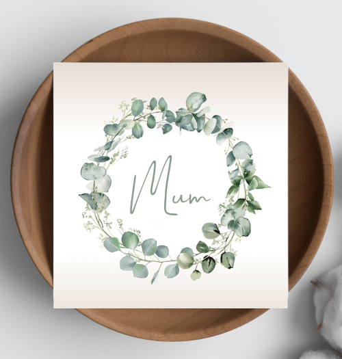 Card with eucalyptus wreath and 'Mum' text on a wooden plate