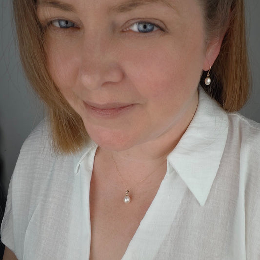 9ct gold pearl necklace, teardrop dangle pendant shown on neck with matching dangle earrings on ear