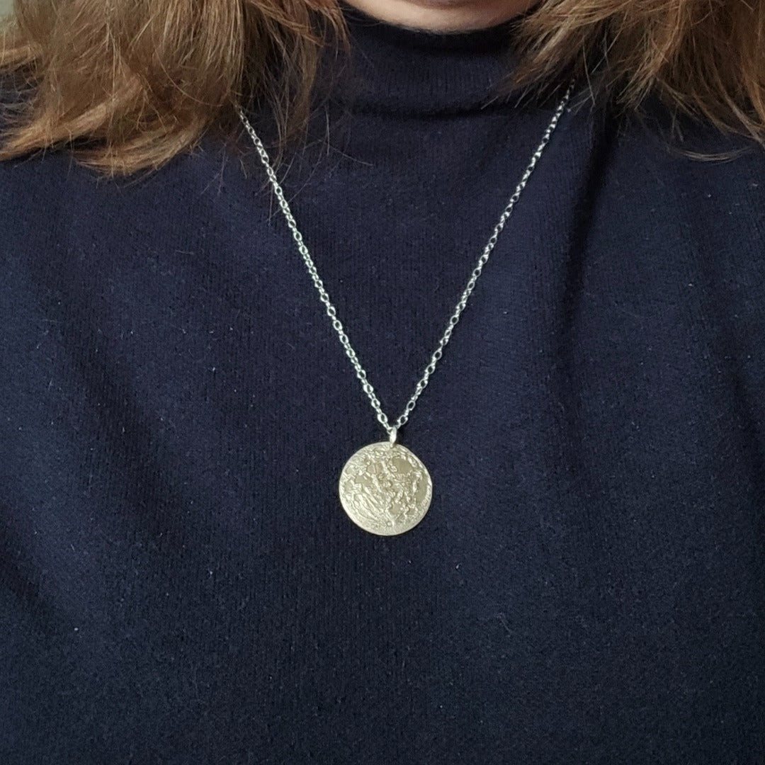 Moon map pendant worn long over a knitted jumper