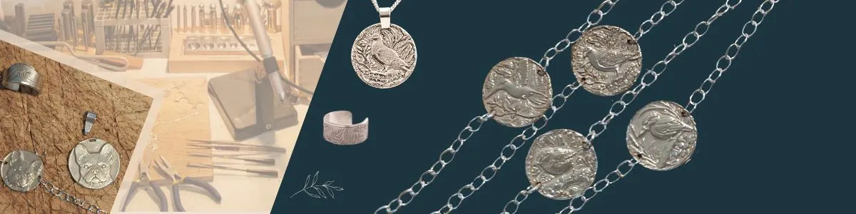 Silver coin pendant necklace, bracelets and an engraved earcuff displayed on dark blue , with a sepia-toned workshop background showing tools and a wooden board.