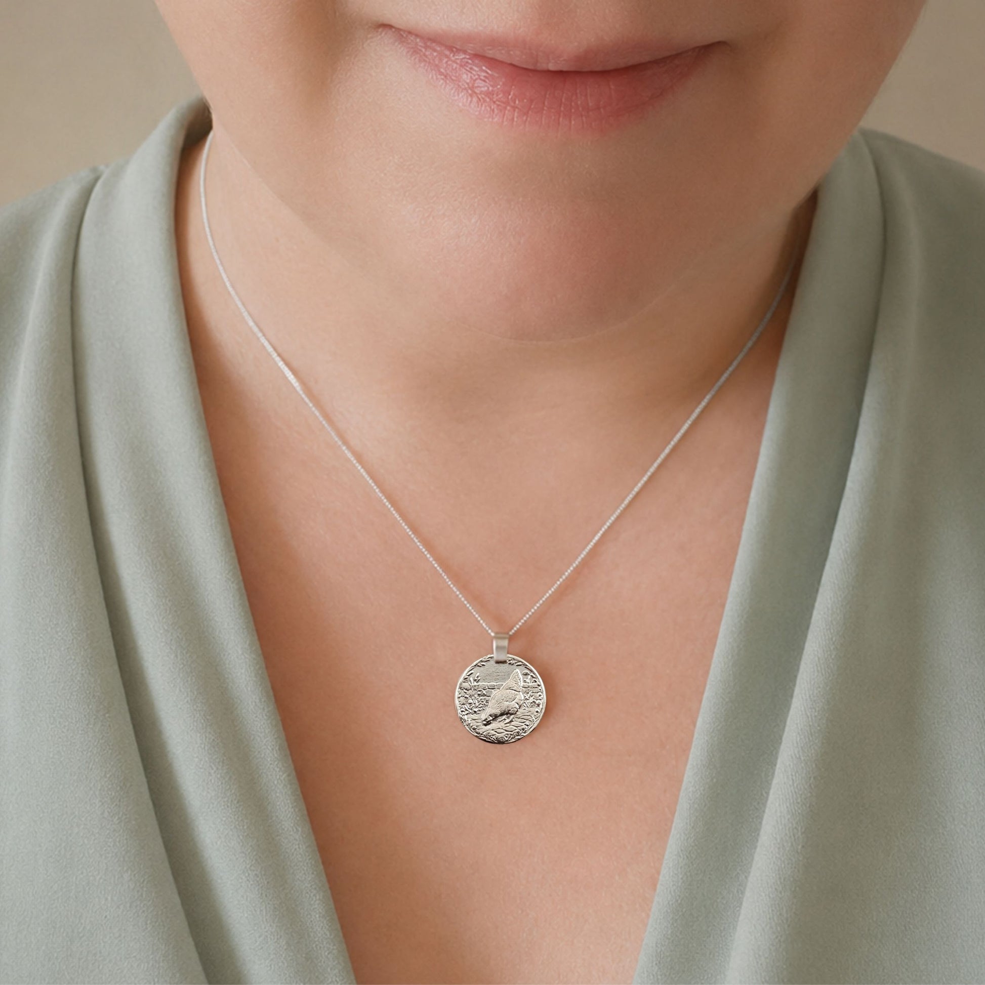 Model wearing the Chicken engraved sterling silver coin pendant necklace, handcrafted in the UK from recycled sterling silver