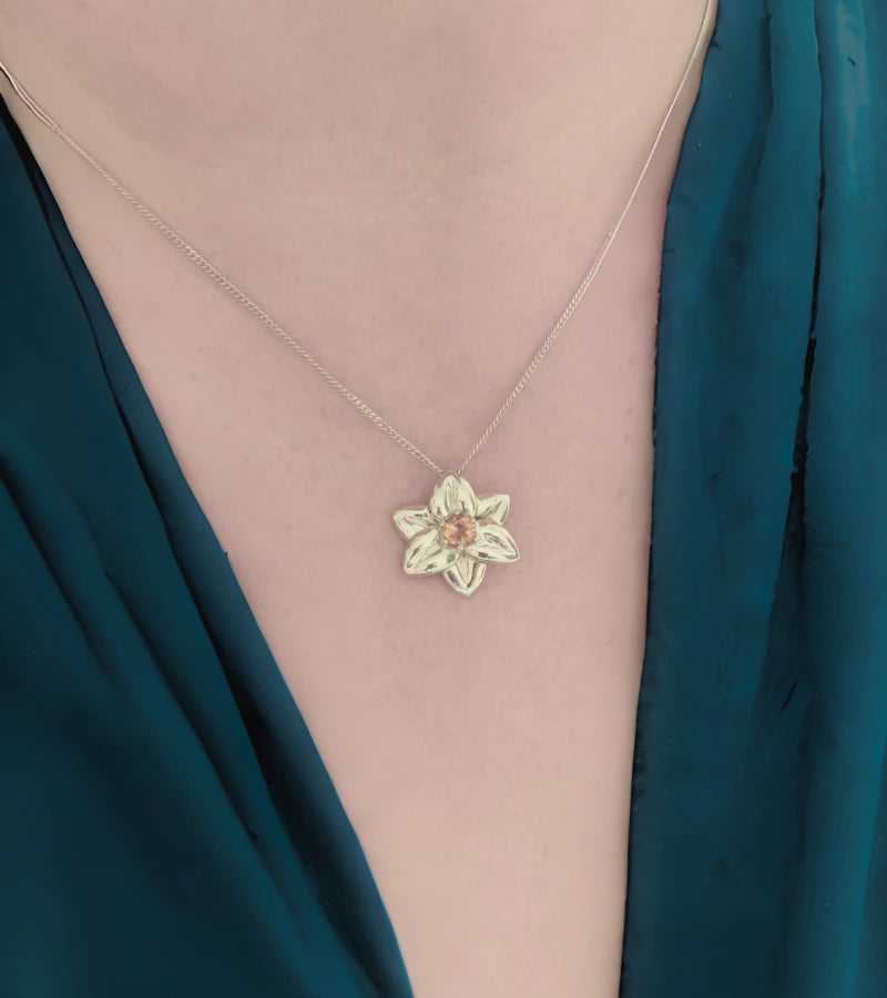 Necklace with a daffodil pendant set with citrine shown on neck