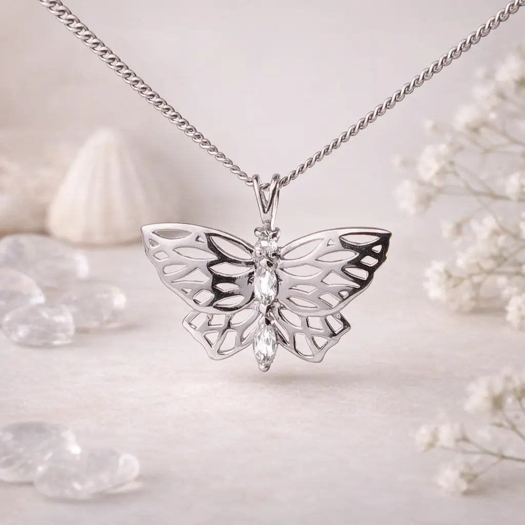 sterling silver butterfly pendant set with white topaz with natural elements in the background