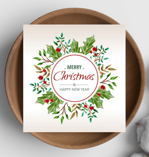 Christmas card with holly design on a wooden plate