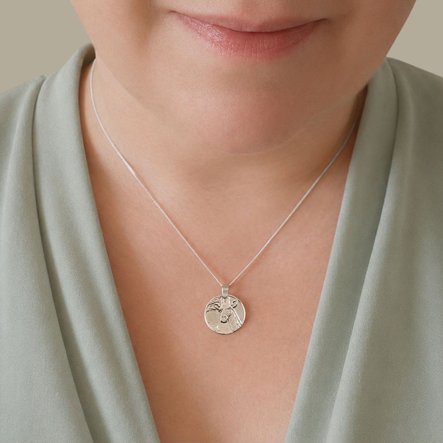 Model wearing the Giraffe engraved sterling silver coin pendant necklace, handcrafted in the UK from recycled sterling silver