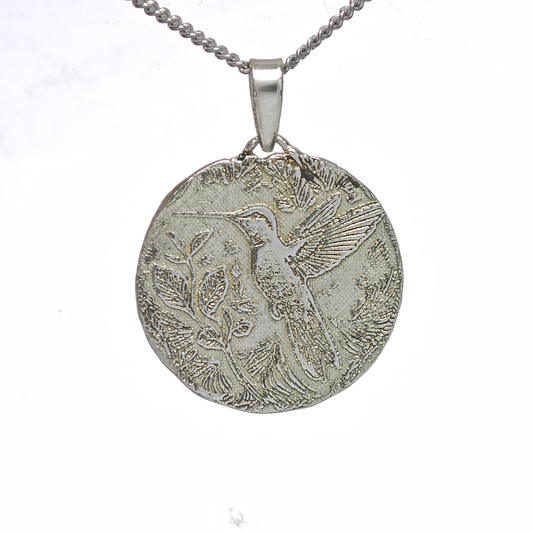 Silver pendant with bird design on a white background