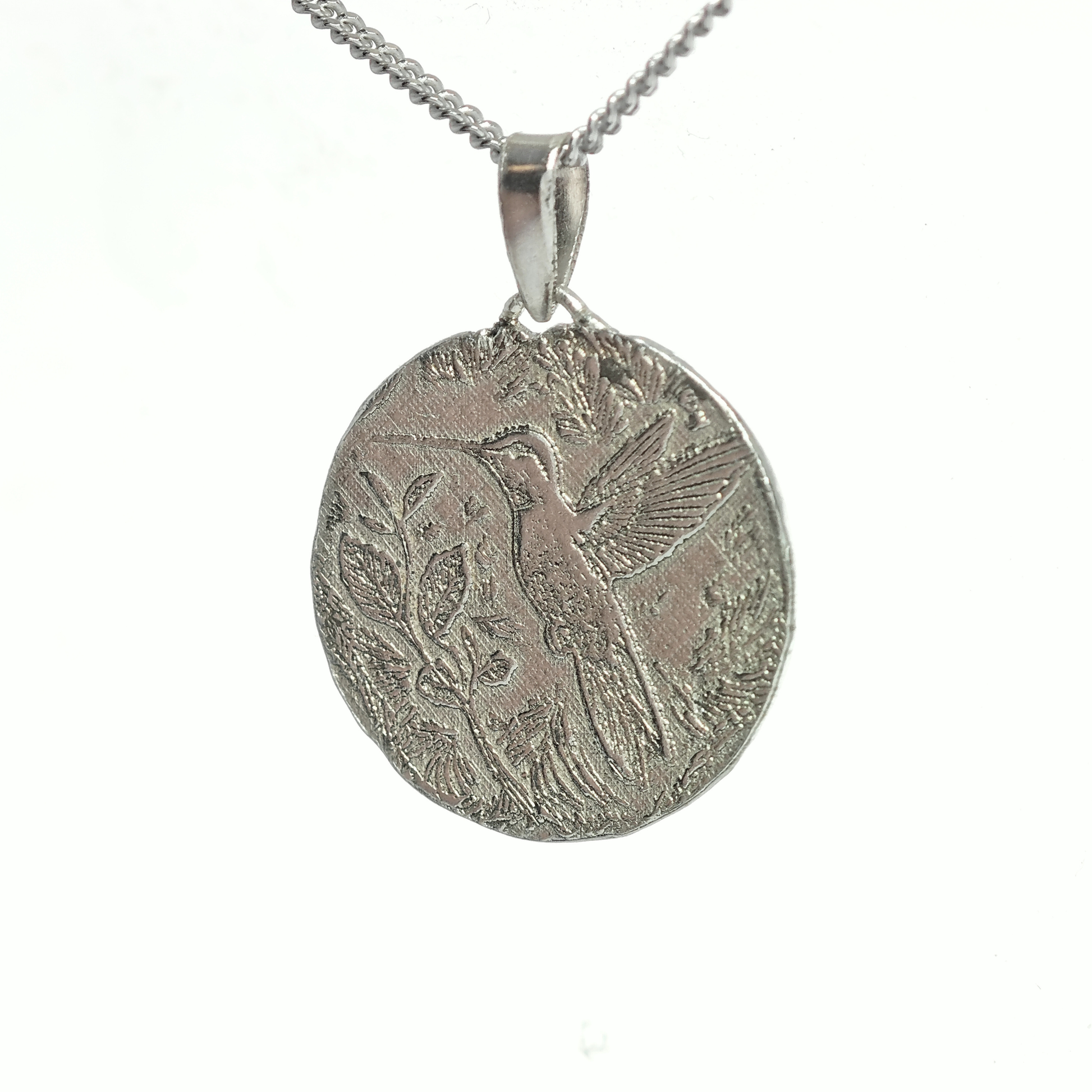 Silver pendant with bird design on a white background