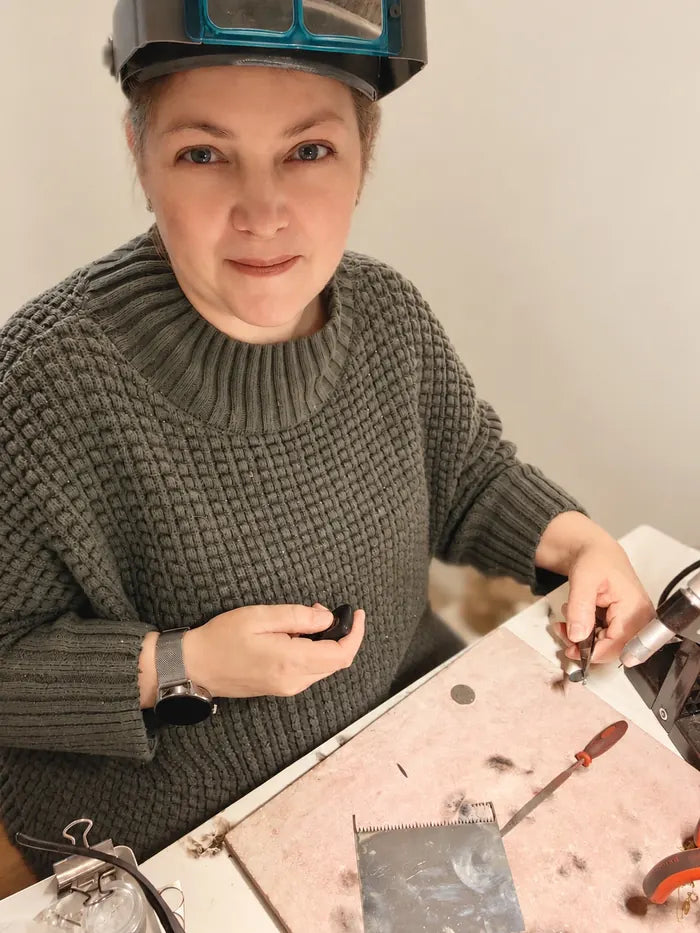 Lindsay, founder of Ojewellery, at her jewellery bench finishing a sterling silver pendant