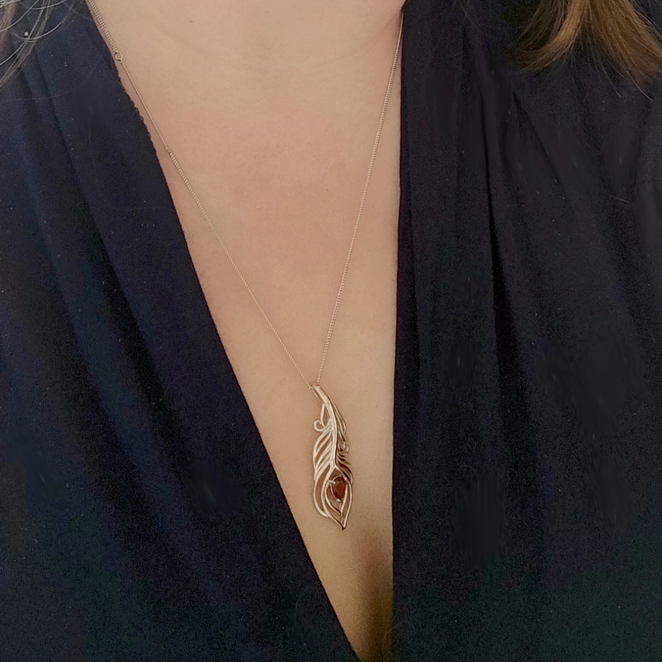 Garnet peacock feather statement pendant on model
