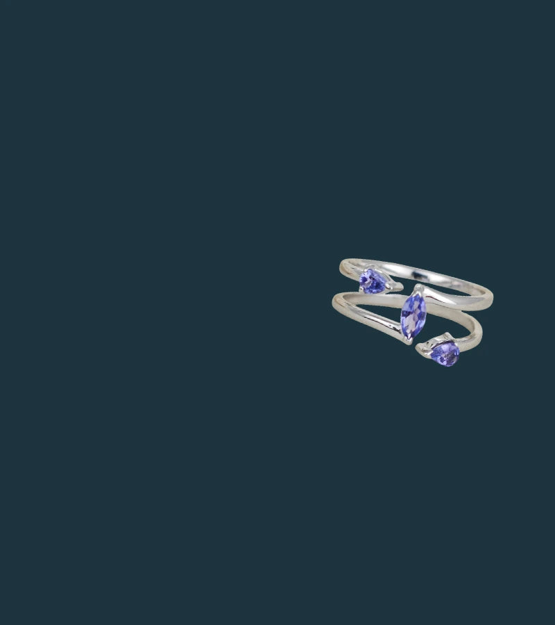 Silver ring with tanzanite gemstones on a dark background